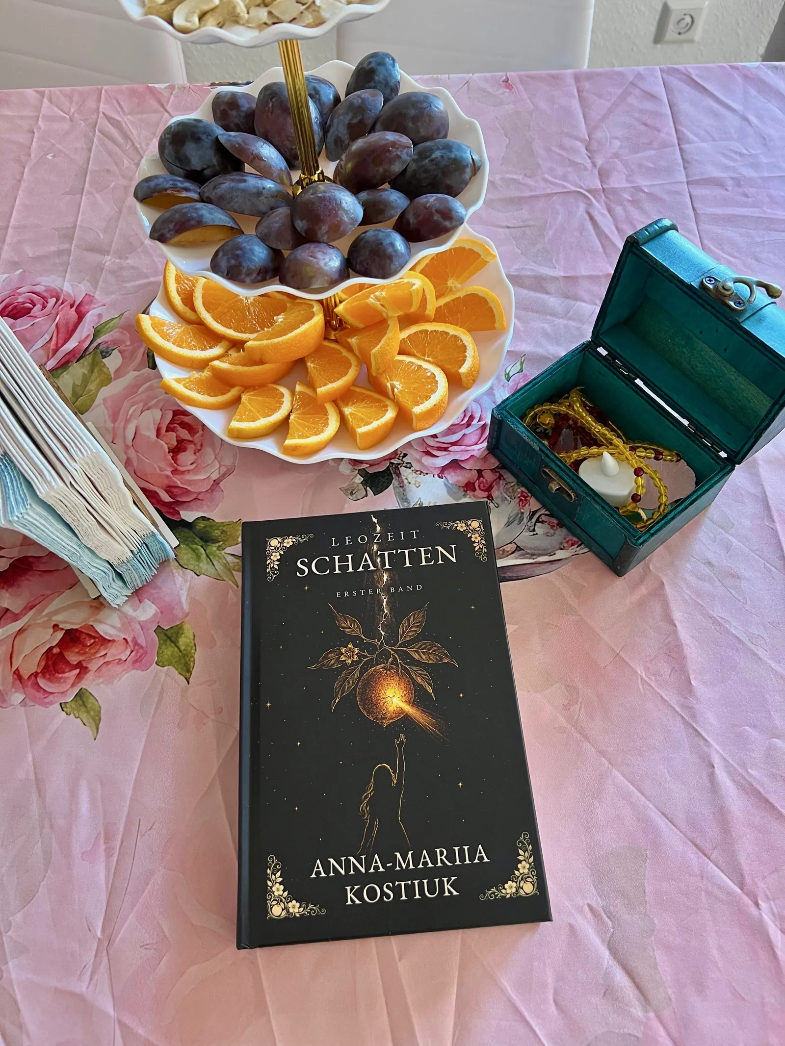 Der gedeckte Tisch: Obst, Rosen — und das Buch